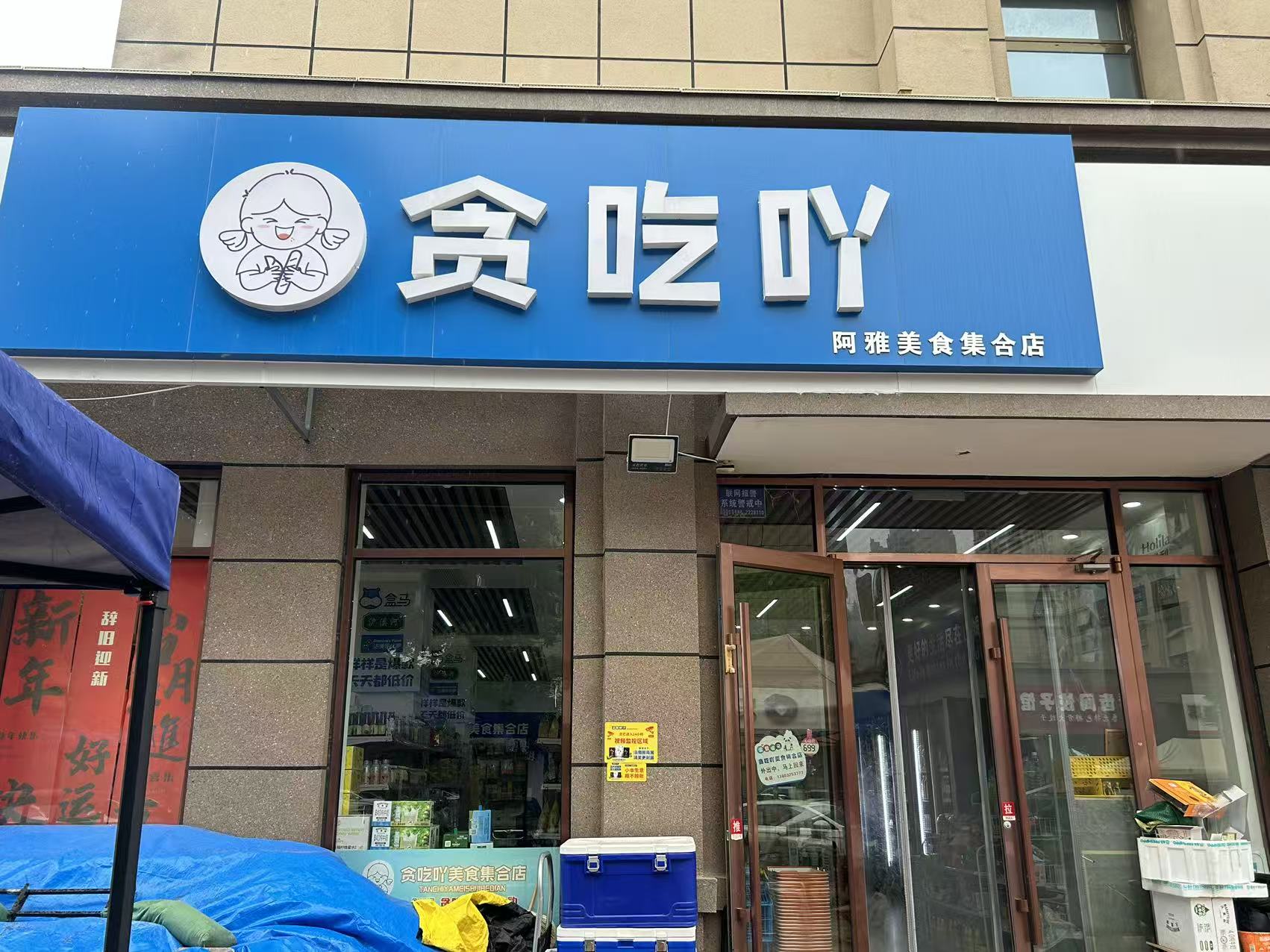 任丘万锦新城B区贪吃吖美食集合店蓝色门头，招牌同时显示阿雅美食集合店